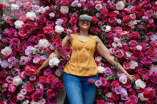 Reife Frau mit VR-Brille liegt auf Blumen