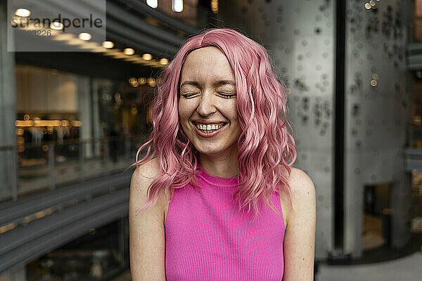 Cheerful young woman with pink dyed hair