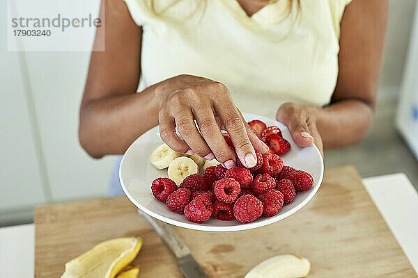 Frau mit Obstteller in der Küche