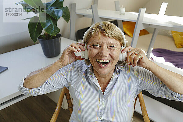 Fröhliche Seniorin hört Musik über kabellose Kopfhörer