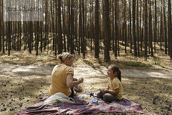 Reife Frau und Mädchen genießen Picknick im Wald