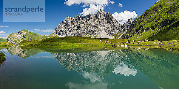 Spiegelung der Allgäuer Alpen im Eissee an einem sonnigen Tag