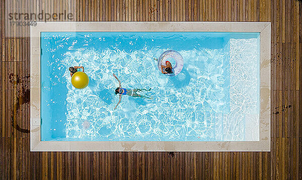 Mother with children enjoying swimming in pool