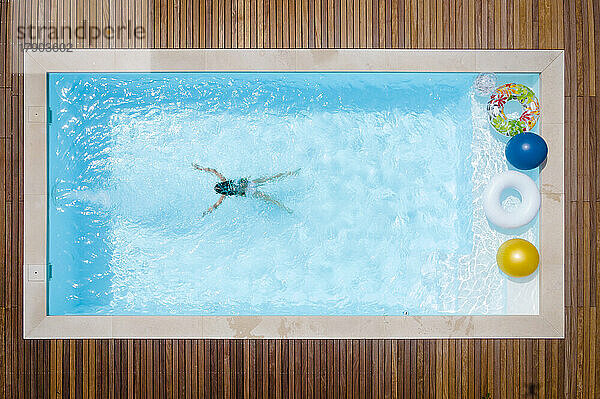 Mädchen schwimmt an einem sonnigen Tag im Pool