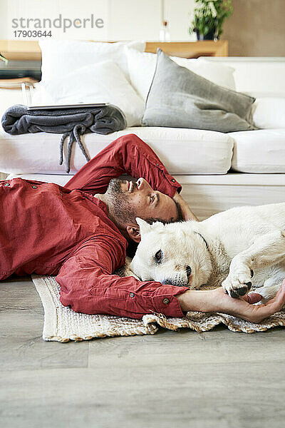 Man and dog lying together at home