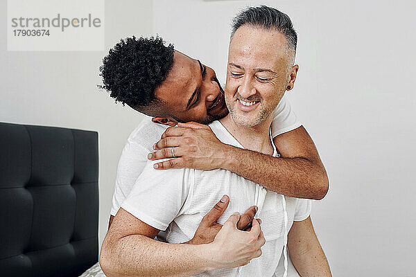 Romantic young man embracing boyfriend at home