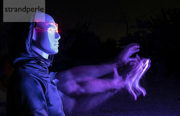 Digital generiertes Bild eines Roboters mit verschwommener Hand im Dunkeln