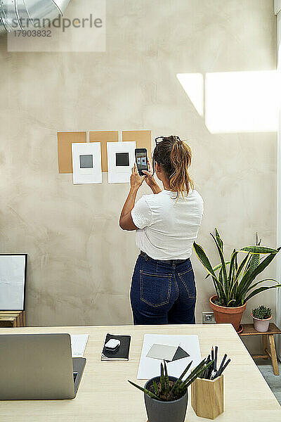 Freiberufler fotografiert die Geschäftsstrategie an der Wand im Heimbüro