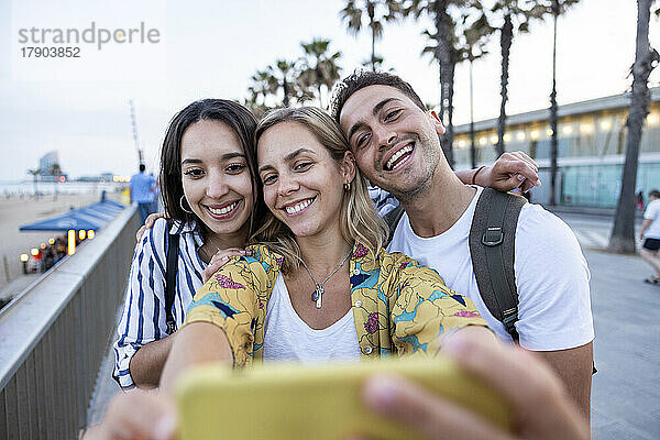 Glückliche junge Frau  die Selfie mit Freunden macht
