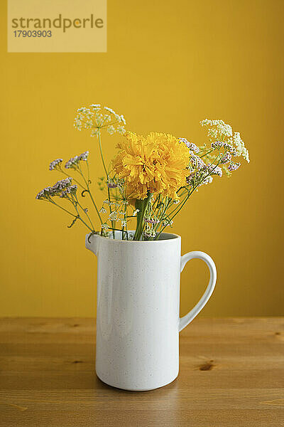 Blumen in weißer Vase auf dem Tisch