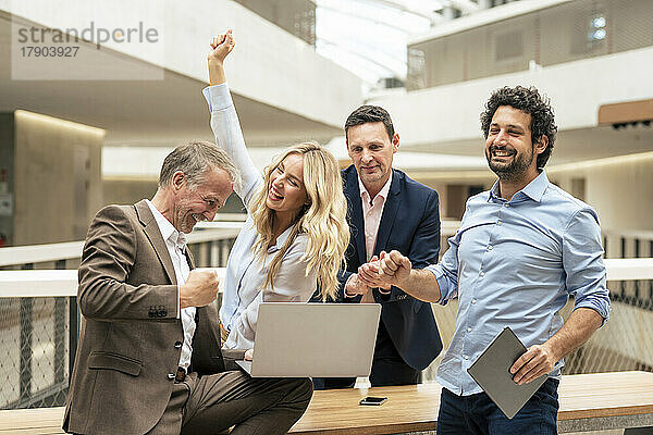 Fröhliche Geschäftskollegen feiern den Erfolg im Büro