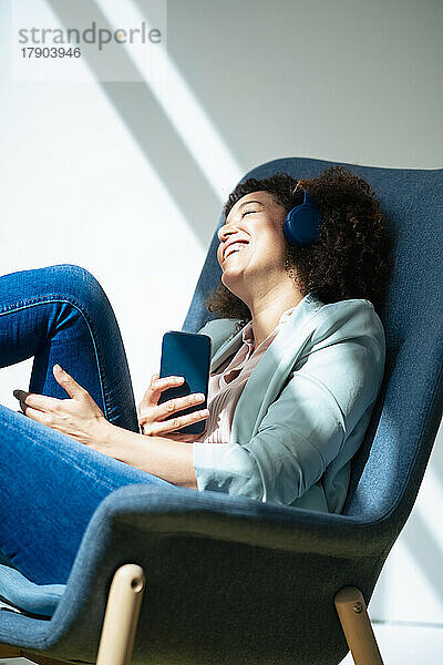 Geschäftsfrau mit Smartphone entspannt sich in der Pause am Arbeitsplatz