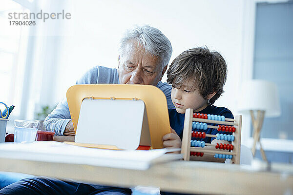 Älterer Mann und Junge nutzen Tablet-PC zu Hause