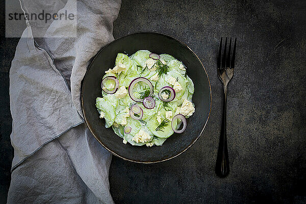 Studio shot of bowl of cucumber salad with yogurt  onions and feta cheese