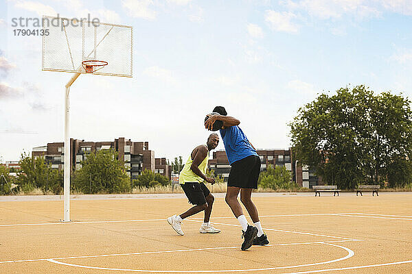 Sohn und Vater spielen auf dem Basketballplatz