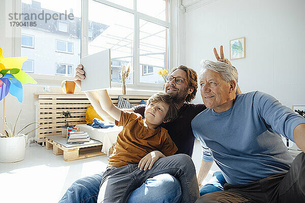 Junge macht zu Hause ein Selfie mit Vater und Großvater per Tablet-PC