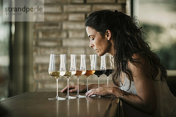 Reife Frau riecht Weine in Gläsern im Restaurant
