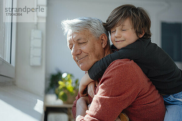 Großvater und Enkel mit geschlossenen Augen zu Hause