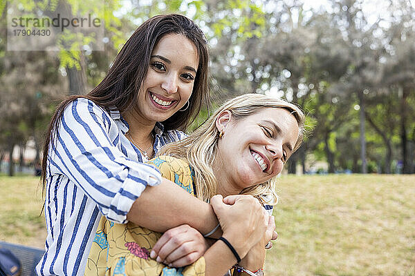 Glückliche junge Frau genießt es mit einer Freundin im Park