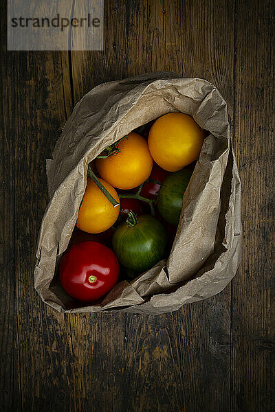 Red  green and yellow tomatoes in paper bag