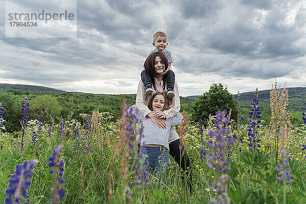Junge Frau mit Kindern auf der Wildblumenwiese