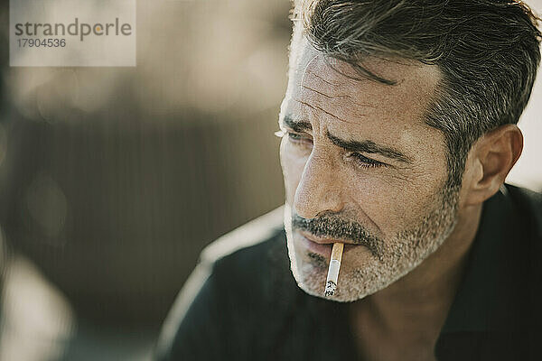 Depressed mature man smoking cigarette