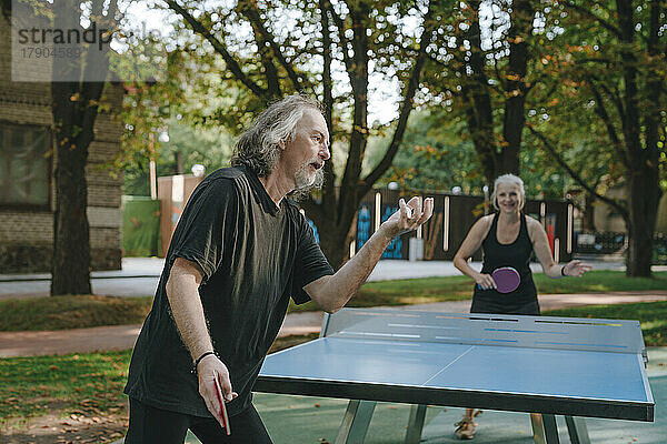 Paar spielt Tischtennis im Park