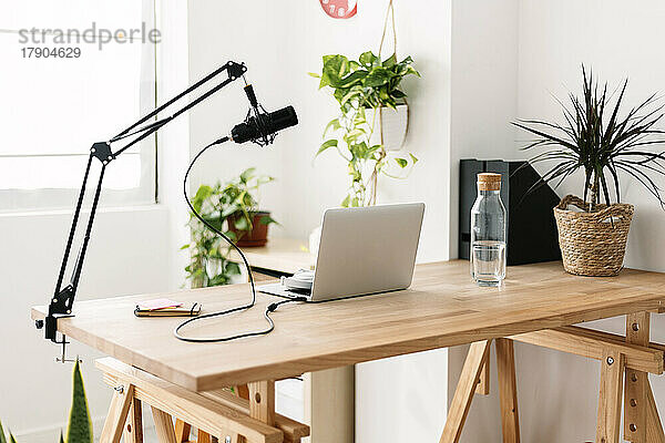 Laptop und Mikrofon auf dem Tisch im Heimstudio