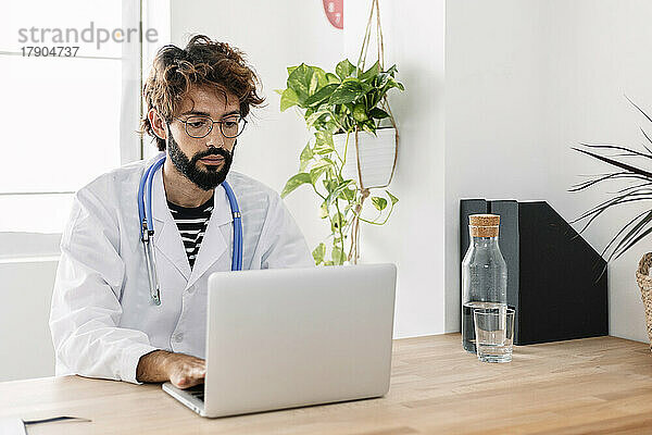 Arzt nutzt Laptop und arbeitet im Heimbüro