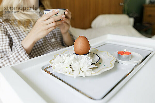 Frau frühstückt zu Hause gesund im Bett