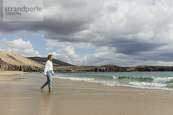 Young woman walking on seashore at beach