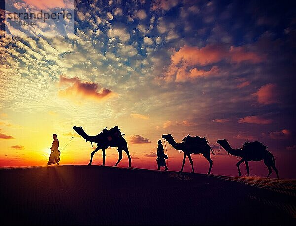 Vintage Retro-Effekt gefiltert Hipster-Stil Bild von Rajasthan Reisen  zwei indische Kameltreiber mit Kamelen Silhouetten in den Dünen der Wüste Thar bei Sonnenuntergang. Jaisalmer  Rajasthan  Indien  Asien