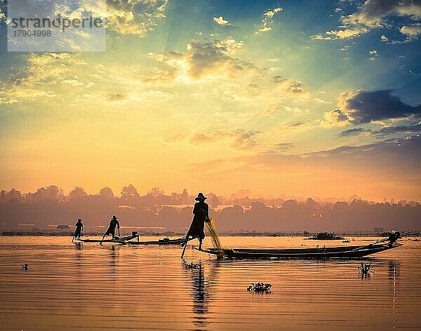 Myanmar Reiseattraktion Wahrzeichen  traditionelle burmesische Fischer sihouettes am Inle See bei Sonnenuntergang  Myanmar berühmt für ihre unverwechselbaren einbeinigen Ruderstil