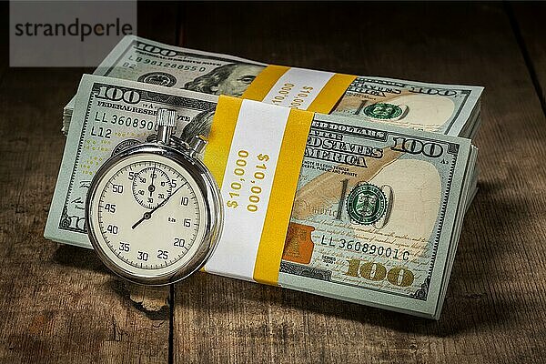Zeit ist Geld Darlehen Konzept Hintergrund  Stoppuhr und Stapel von neuen 100 US-Dollar 2013 Ausgabe Banknoten Rechnungen Bündel auf hölzernen Hintergrund