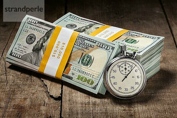 Zeit ist Geld Darlehen Konzept Hintergrund  Stoppuhr und Stapel von neuen 100 US-Dollar 2013 Ausgabe Banknoten Rechnungen Bündel auf hölzernen Hintergrund