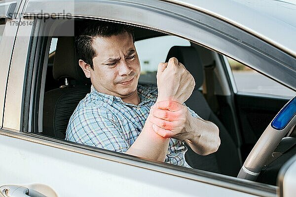 Wunde Fahrer Mann berührt sein Handgelenk. Fahrer mit Handschmerzen. Suffering Fahrer am Steuer reibt seinen Arm von so viel Fahren  Sore Mann müde vom Fahren  Fahrer leidet unter Schmerzen im Handgelenk