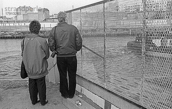 DDR  Berlin  23. 02. 1990  Spreebogen  Blick über die Spree zur Mauer auf der Ostseite  Charité Hochhaus  Personen am Ufer