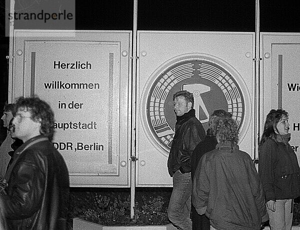 DDR  Berlin  09. 11. 1989  Öffnung der Berliner Mauer  Grenzübergang Bornholmer Straße  DDR Embleme und Willkommensgruß  DDR Bürger strömen in den Westen