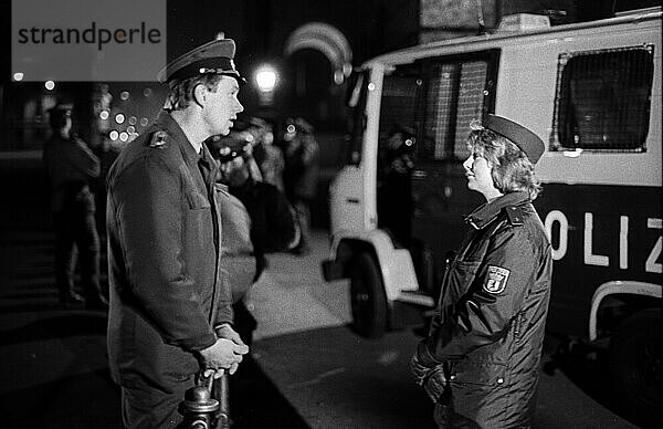 DDR  Berlin  21. 02. 1990  Abriß der Mauer am Reichstag  ein Volkspolizist und eine Polizistin aus dem Westen im Gespräch? (Abriß der Mauer am Reichstag)