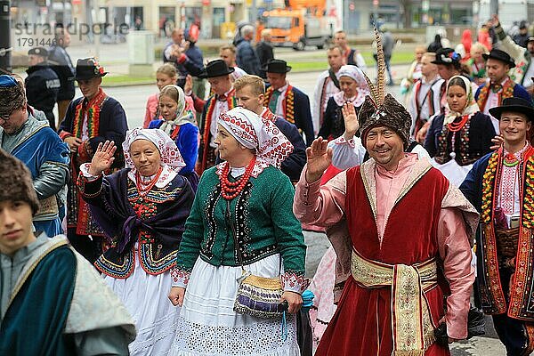 Ein Mann winkt bei der Trachten- und Schützenparade auf dem Oktoberfest  bei der die Menschen farbenprächtige Trachten und Kleider tragen  in die Kamera. München  Deutschland  Europa