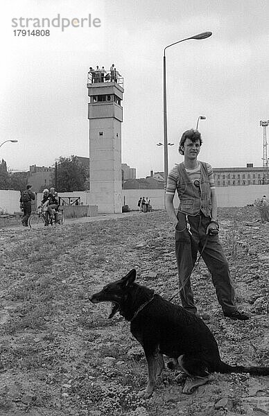 DDR  Berlin  13. 06. 1990  Mauer an der geschichtsträchtigen Bernauer Straße (Nordbahnhof)  Jugendlicher mi Hund  Wachturm  © Rolf Zoellner