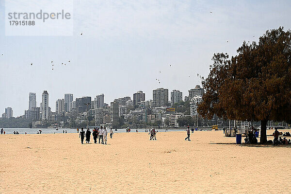 Menschen spazieren am Juhu-Strand  Hochhäuser im Hintergrund  Mumbai  Indien  Asien