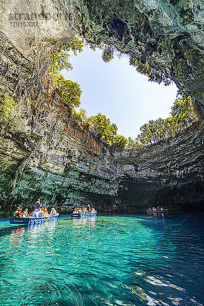 Touristen bewundern die Höhle während einer Bootsfahrt auf dem kristallklaren Wasser des Melissani-Sees  Kefalonia  Ionische Inseln  Griechische Inseln  Griechenland  Europa