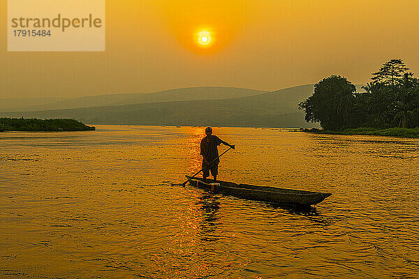 Mann in seinem Einbaum bei Sonnenuntergang auf dem Kongo-Fluss  Demokratische Republik Kongo  Afrika