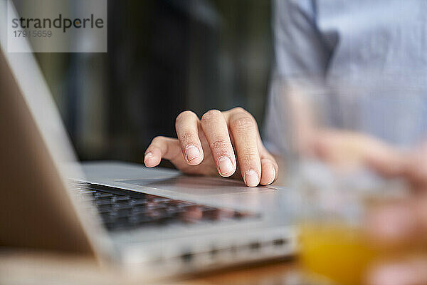Nahaufnahme einer Frauenhand beim Tippen auf einem Laptop in einem Büro im Freien