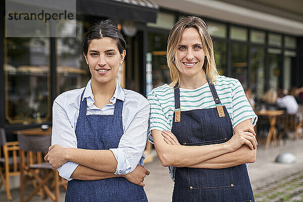 Mittelaufnahme von zwei Restaurantbetreiberinnen  die vor ihrem Geschäft posieren