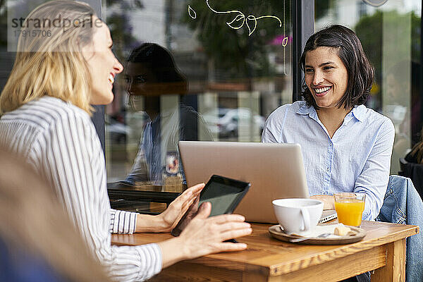 Mid-shot von zwei lächelnden weiblichen Mitarbeiter genießen ihre Arbeit im Freien Büro