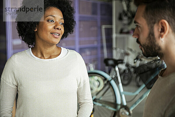 Afroamerikanische Frau im Gespräch mit dem Besitzer eines Fahrradladens