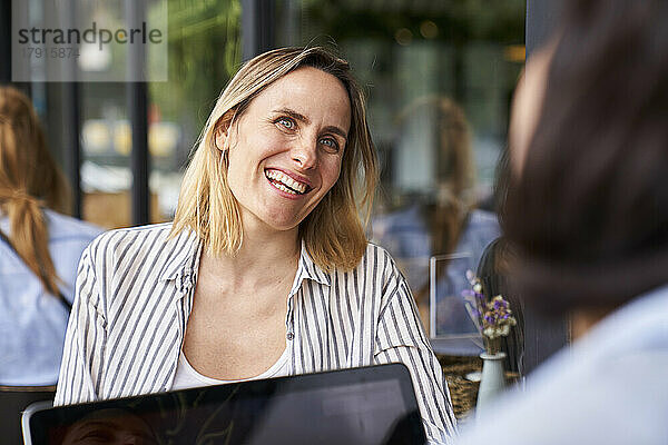 Frontansicht einer amüsierten Unternehmerin  die sich bei der Arbeit im Büro im Freien mit ihrem Partner amüsiert