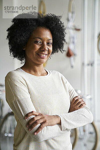 Mittlere Einstellung einer afroamerikanischen Unternehmerin  die in die Kamera schaut  während sie in ihrem Geschäft steht